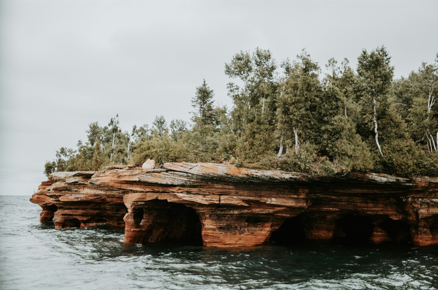 Coastline of Lake Superior with some sea caves cut into sandstone.