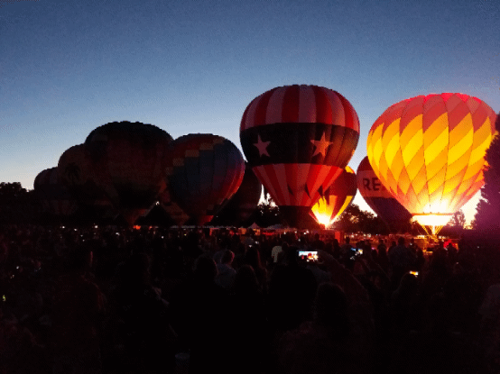 Synchronized lights and music at a night glow hot air balloon festival 
