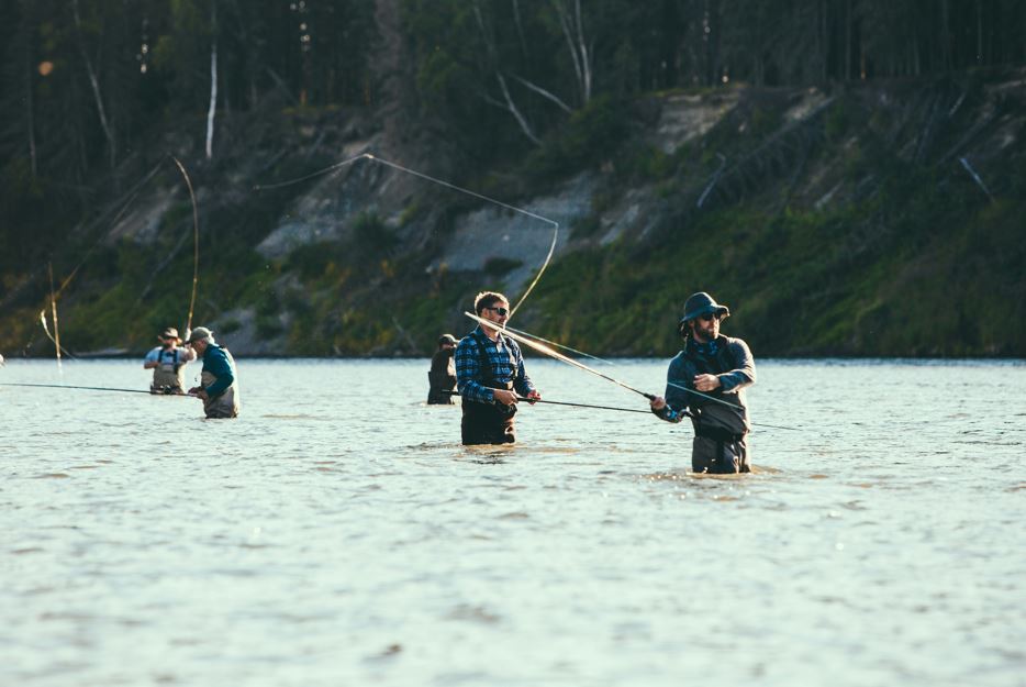 Fishermen wade in the icy waters of Alaska casting their reels.