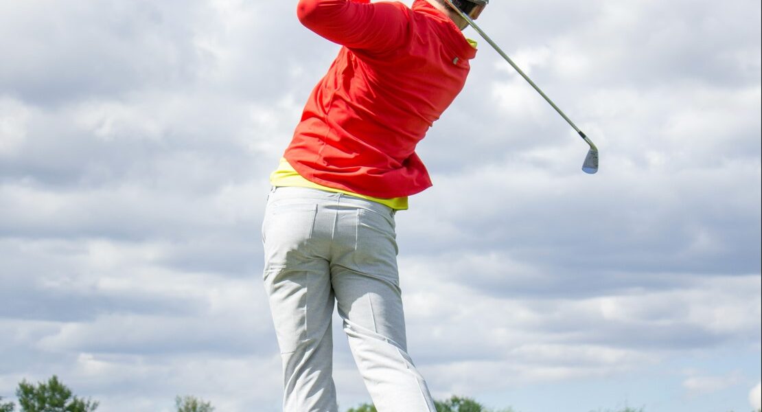 Man takes a swing at a golf ball at a golf course in Destin, FL