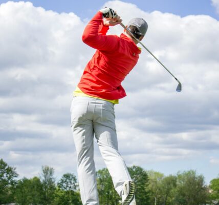 Man takes a swing at a golf ball at a golf course in Destin, FL