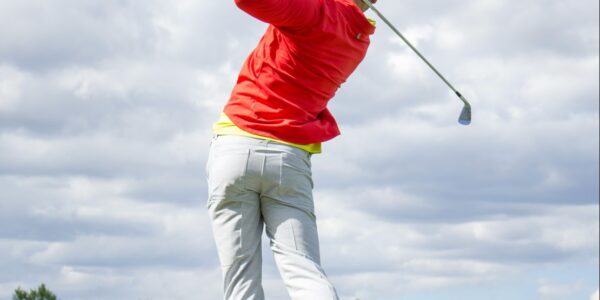 Man takes a swing at a golf ball at a golf course in Destin, FL