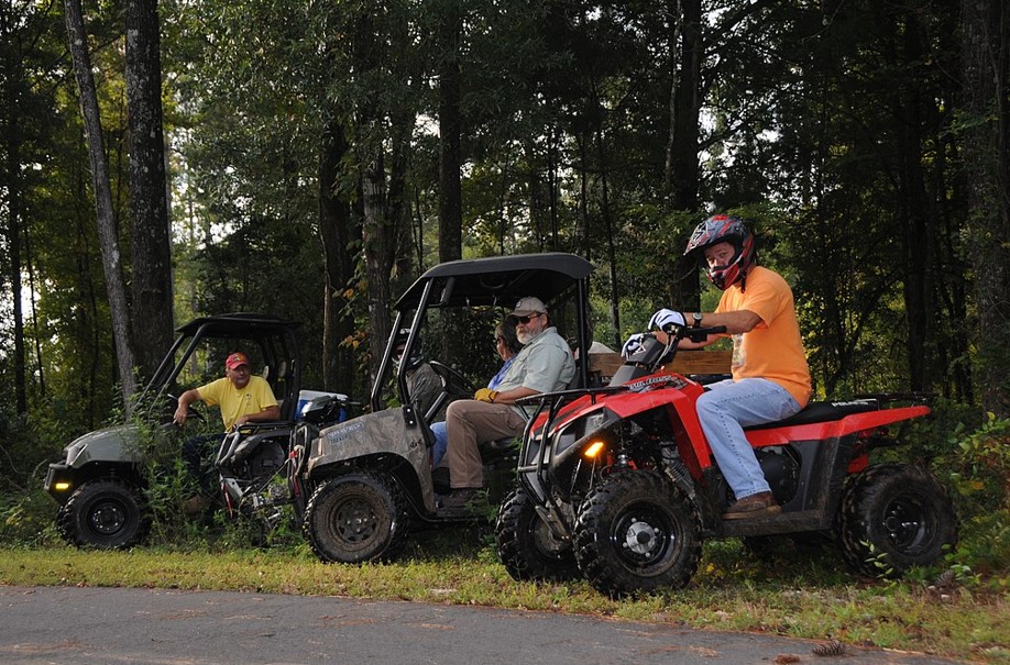 Several different types of off road vehicles wait at the trailhead. 
