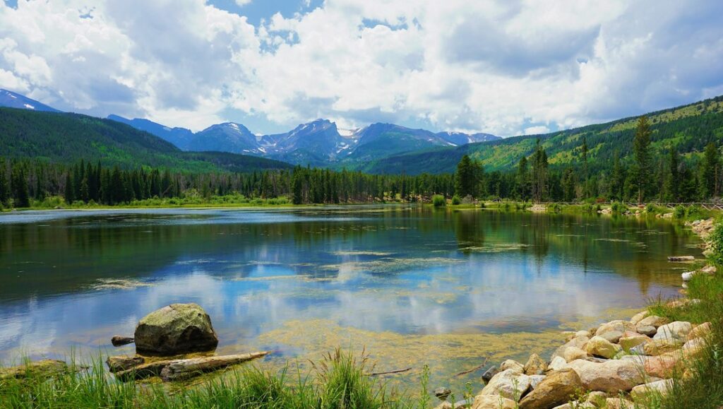 Beautiful lake in Estes Colorado with snow capped mountains in the distance.