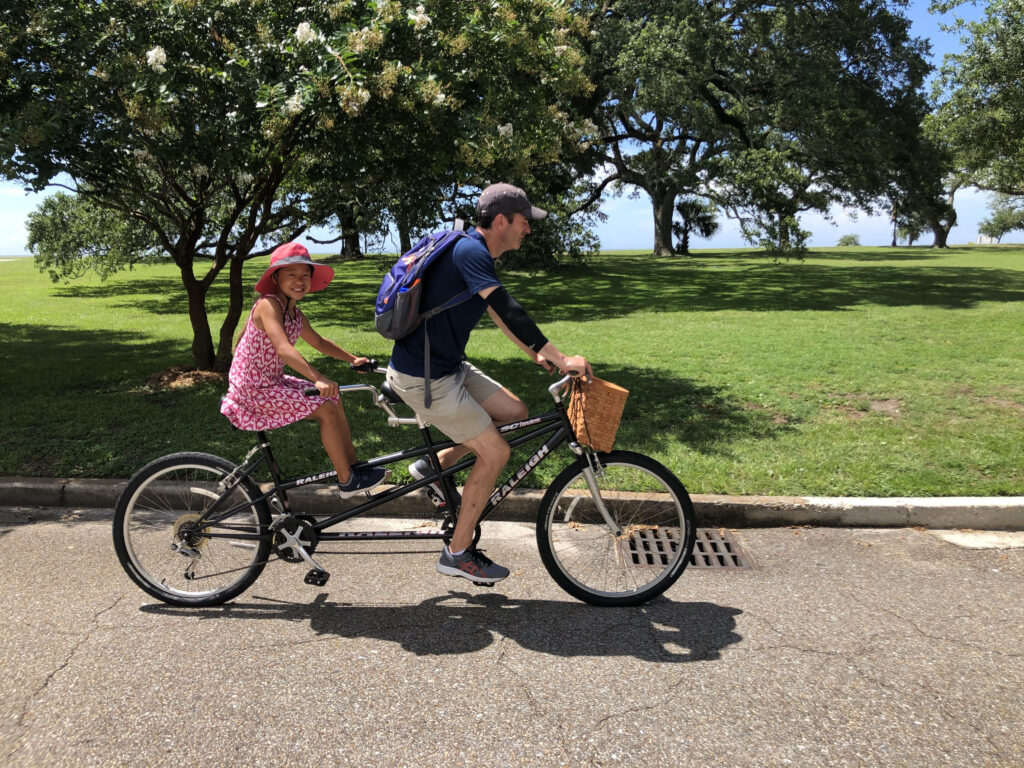 Jim and our daughter enjoy a tandem bike ride along the gulf coast.