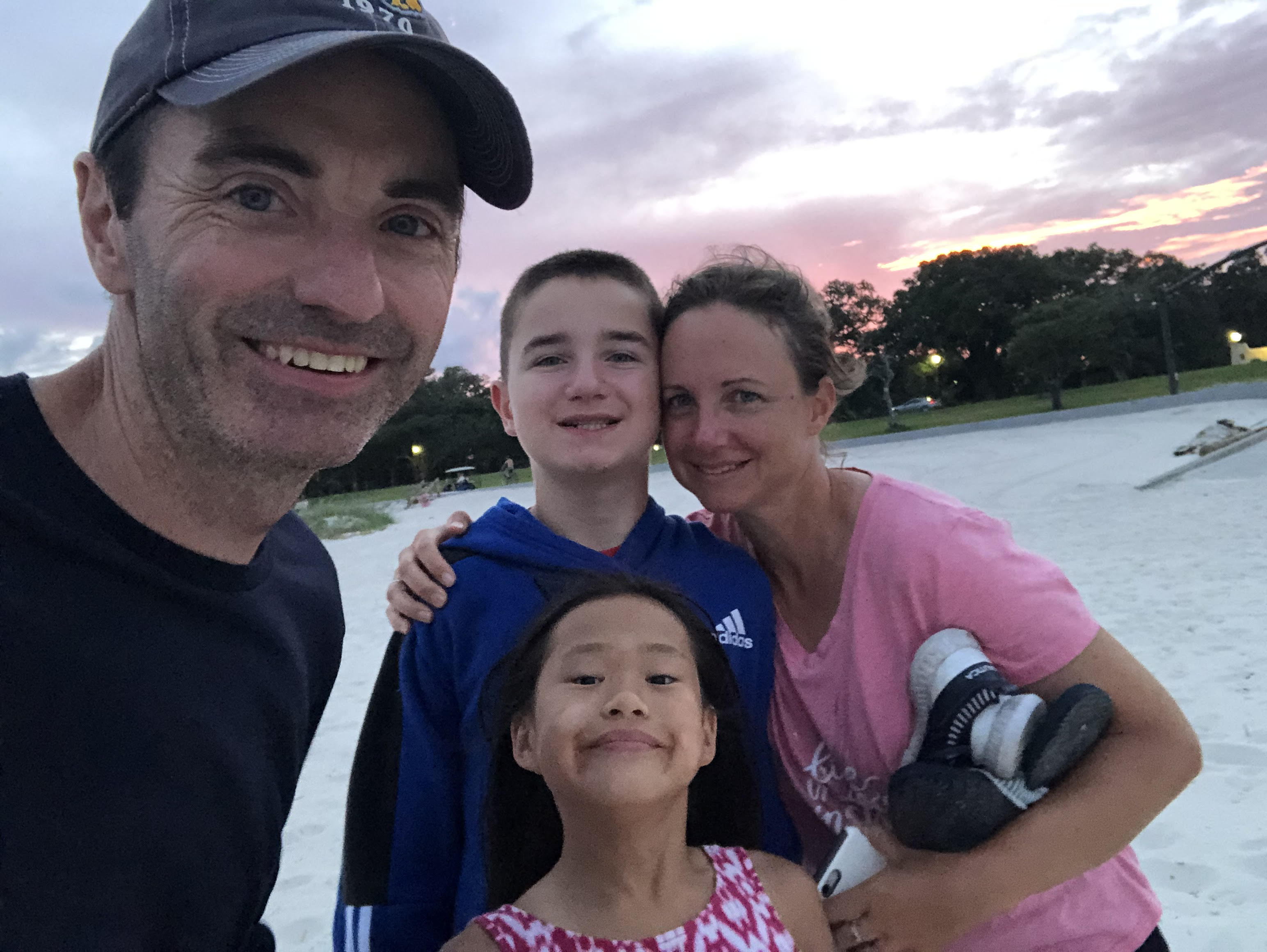 Our family takes a selfie on the beach at sunset.