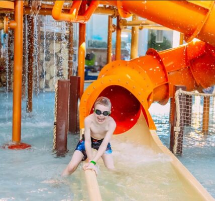 Boy laughs at the bottom of a slide in one of the water parks in jersey city.