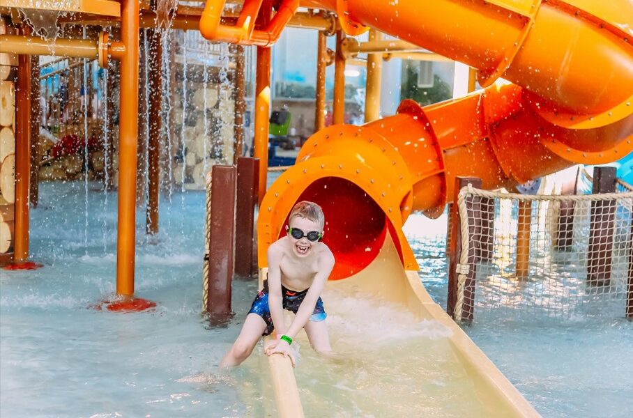 Boy laughs at the bottom of a slide in one of the water parks in jersey city.
