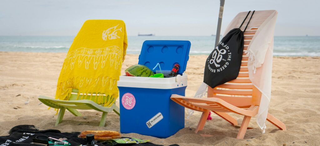 A couple of beach chairs sit on the white sand beaches of Mississippi. A blue cooler of snacks and drinks is positioned in-between the chairs.