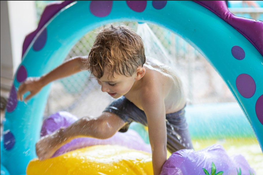 A boy climbs through a water adventure splash pad at one of the water parks in Jersey City.