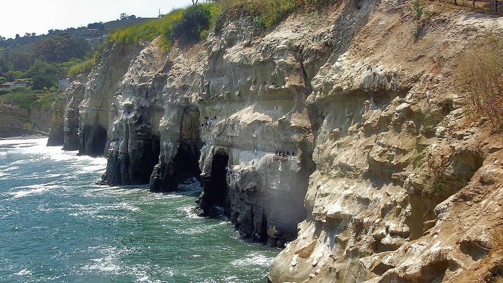 A ocean pounds against the cliffs which have created 7 sea caves.